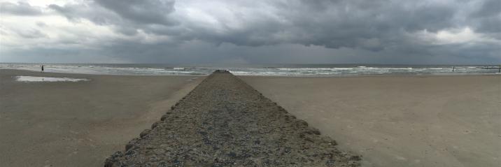 Buhne an der Nordsee mit tief schwarzen Wolken